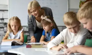 Nauczycielka wspiera uczniów w nauce, pokazując swoje kompetencje rady pedagogicznej. Dzieci skupione na książkach.