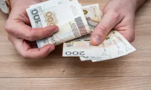 Ręce liczą banknoty 100 i 200 zł. To pieniądze na wymarzone wczasy pod gruszą, by odpocząć od codzienności.
