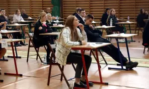 Uczniowie siedzą w ławkach podczas egzaminu, rozpoczynając nowy rok szkolny.