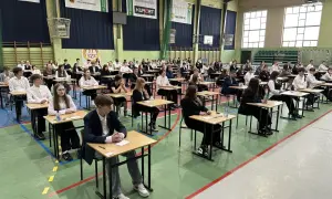 Uczniowie w ławkach podczas egzaminu 8 klasisty 2026. Skupieni, czekają na rozpoczęcie.