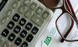 Kalkulator, okulary i dokument ZUS. Przygotowanie zaświadczenia o zarobkach wymaga precyzji i dokładności.