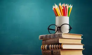 Stos książek, okulary i kolorowe kredki symbolizują drogę do wiedzy, która zaczyna się od wykształcenia średniego.