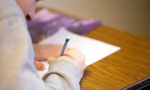 Uczeń pisze wypracowanie na maturze z polskiego, starając się zdobyć jak najwięcej punktów.