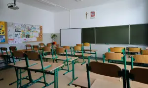Pusta klasa z rzędami ławek i krzeseł, tablicą i projektorem. Może to być dzień przed **dniami dyrektorskimi**, kiedy wszystko jest przygotowane.