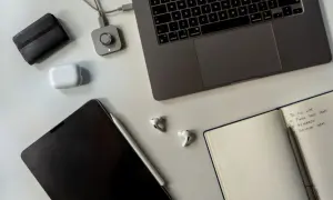 Staż pracy umowa zlecenie: laptop, tablet, słuchawki i notatnik z listą zadań.