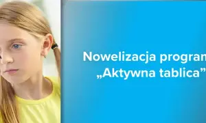 Dziewczynka pisze na szkle, ucząc się z programem „Aktywna tablica”.