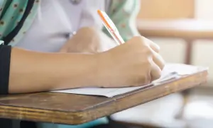 Uczeń pisze na kartkówce, zdobywając wiedzę z zakresu edukacji zdrowotnej.