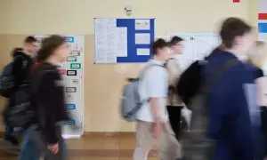 Uczniowie spieszą się korytarzem szkolnym, gdzie wiszą ogłoszenia. Może to być ważna informacja od minister edukacji narodowej.
