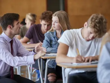 Nauczyciel rozmawia z uczennicą podczas lekcji. Czyżby dyskutowali, jakie lektury były na e8?