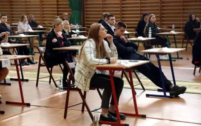 Uczniowie siedzą w ławkach podczas egzaminu, rozpoczynając nowy rok szkolny.