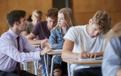 Nauczyciel rozmawia z uczennicą podczas lekcji. Czyżby dyskutowali, jakie lektury były na e8?