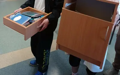 Dzień bez plecaka w szkole. Uczniowie niosą swoje rzeczy w szufladach i szafkach zamiast w plecakach.