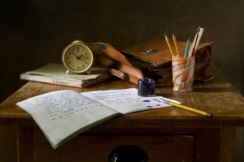 Zestaw do nauki w domu: budzik, zeszyty, pióro, kałamarz i torba. Idealne do **homeschoolingu**.