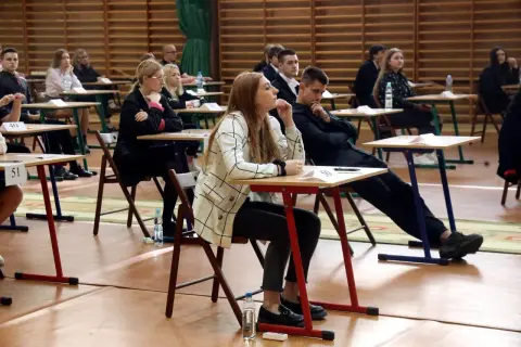 Uczniowie siedzą w ławkach podczas egzaminu, rozpoczynając nowy rok szkolny.