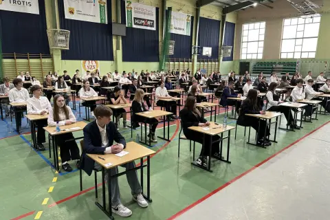 Uczniowie w ławkach podczas egzaminu 8 klasisty 2026. Skupieni, czekają na rozpoczęcie.