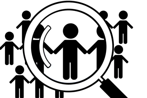 Grupa ludzi trzymających się za ręce, analizowana przez lupę. To symbol diagnozy funkcjonalnej.