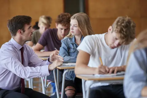 Nauczyciel rozmawia z uczennicą podczas lekcji. Czyżby dyskutowali, jakie lektury były na e8?