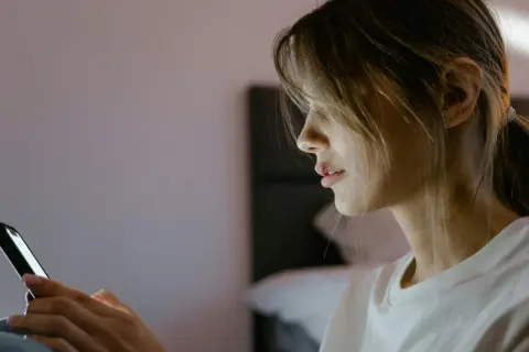 Dziewczyna z lekko rozdartą wargą pisze SMS-a, być może angażując się w seksting.