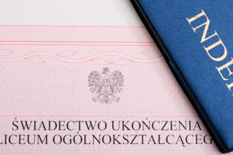 Świadectwo ukończenia liceum i niebieski indeks z napisem "INDEKS" w złotych literach.
