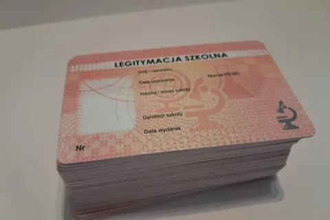 Stos nowych legitymacji szkolnych, gotowych do wypełnienia. Każda zawiera pole na numer legitymacji szkolnej, dane ucznia i szkoły.