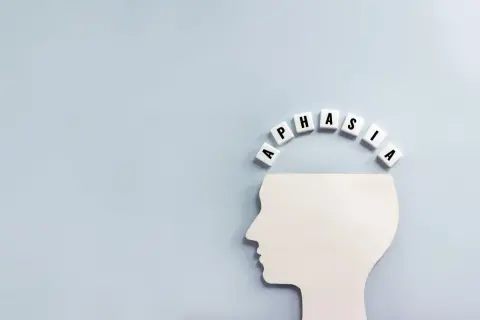 Biały profil głowy z literami tworzącymi słowo "APHASIA" nad nim. Symbolizuje to afazję mieszaną.