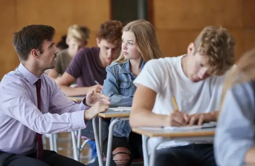 Nauczyciel rozmawia z uczennicą podczas lekcji. Czyżby dyskutowali, jakie lektury były na e8?