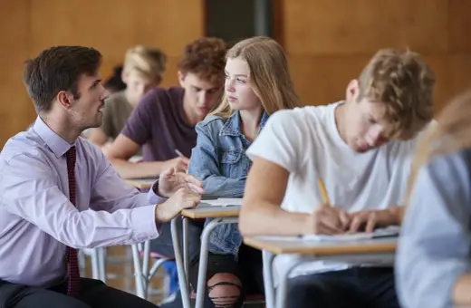 Nauczyciel rozmawia z uczennicą podczas lekcji. Czyżby dyskutowali, jakie lektury były na e8?