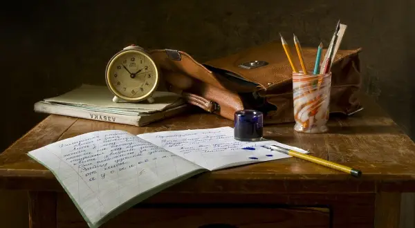 Zestaw do nauki w domu: budzik, zeszyty, pióro, kałamarz i torba. Idealne do **homeschoolingu**.