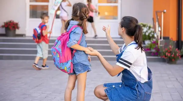 Mama żegna córkę idącą do szkoły. To już obowiązek szkolny 6-latków, czas na naukę i nowe przygody!