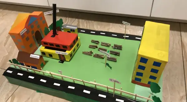 Model miasta z budynkami, tartakiem i stertami drewna. Może posłużyć jako inspiracja do wypracowań o chłopcach z Placu Broni dla klasy 5.