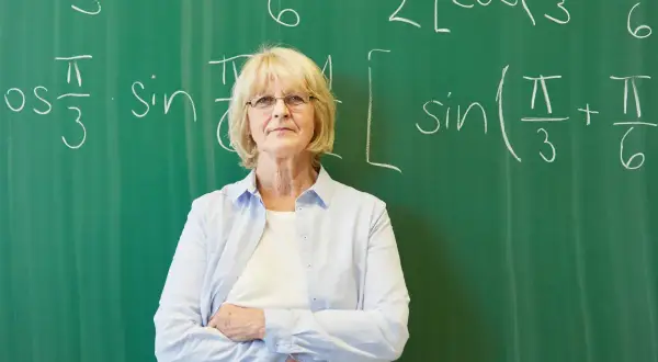 Nauczycielka matematyki przed tablicą z równaniami. Czyżby szykowała się nowelizacja Karty Nauczyciela?
