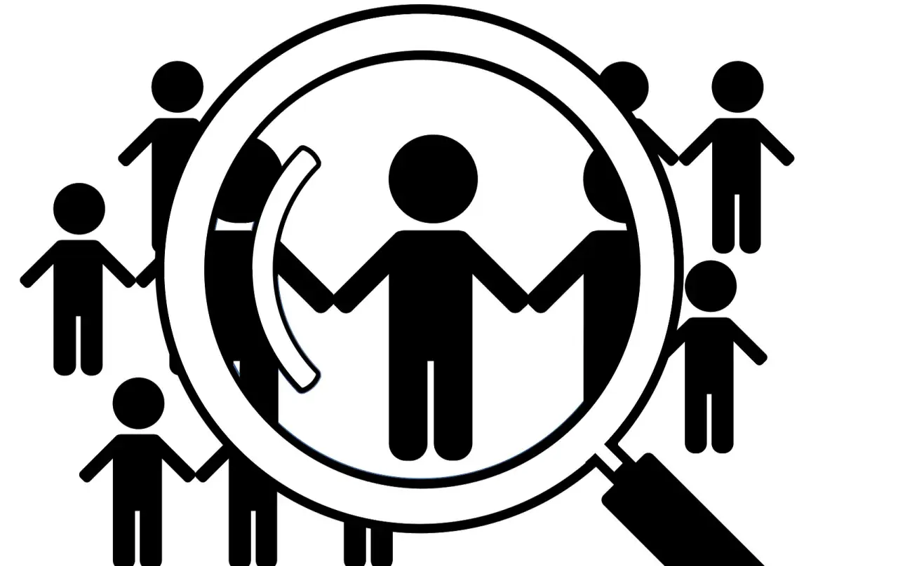 Grupa ludzi trzymających się za ręce, analizowana przez lupę. To symbol diagnozy funkcjonalnej.