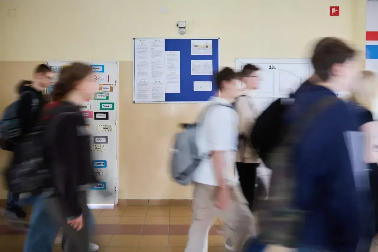 Uczniowie spieszą się korytarzem szkolnym, gdzie wiszą ogłoszenia. Może to być ważna informacja od minister edukacji narodowej.
