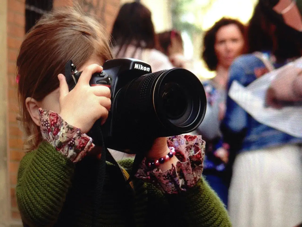 Dziecko z aparatem Nikon, jakby przejęło rolę rodzica, dokumentując świat.