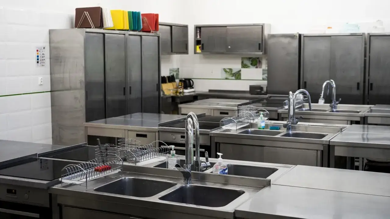 Profesjonalna kuchnia szkolna dla technika żywienia i usług gastronomicznych. Stal nierdzewna, zlewy, płyty grzewcze, szafki.