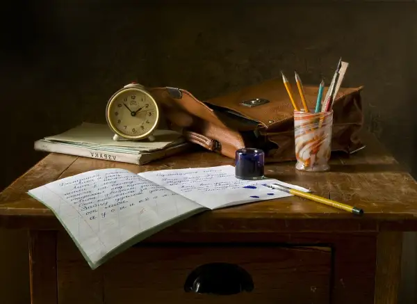 Zestaw do nauki w domu: budzik, zeszyty, pióro, kałamarz i torba. Idealne do **homeschoolingu**.