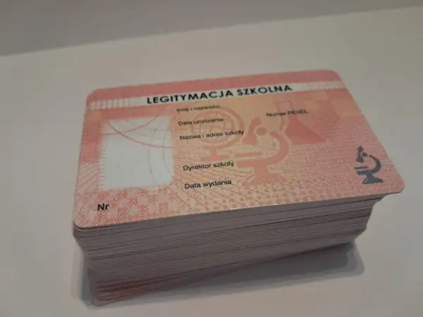 Stos nowych legitymacji szkolnych, gotowych do wypełnienia. Każda zawiera pole na numer legitymacji szkolnej, dane ucznia i szkoły.