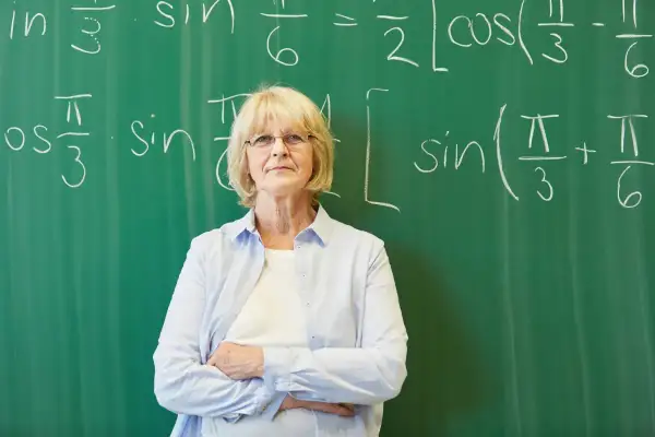 Nauczycielka matematyki przed tablicą z równaniami. Czyżby szykowała się nowelizacja Karty Nauczyciela?