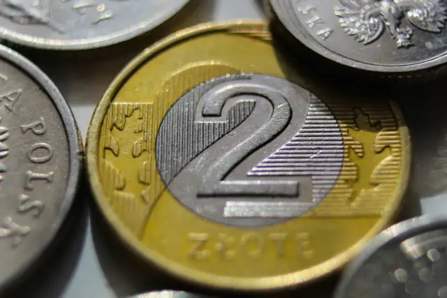 Dwie polskie monety dwuzłotowe, symbolizujące zarobki i minimalną stawkę godzinową.